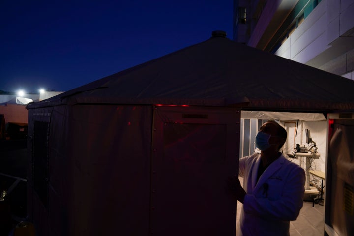 Dr. Jim Keany, an emergency medicine specialist, shuts the door of a triage tent set up to treat COVID-19 patients at Mission