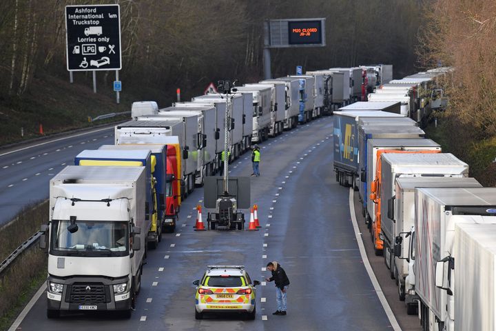 Police speak with a driver as freight lorries remain queued up on the M20 leading to the Port of Dover on Christmas Eve