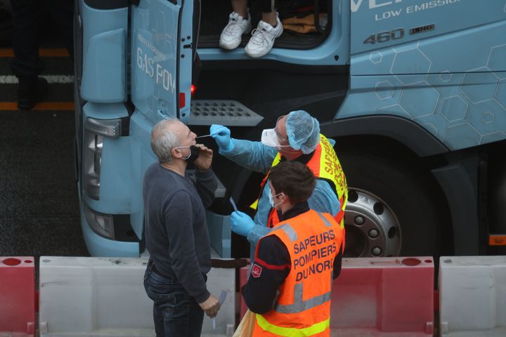 A firefighter swabs a lorry driver to test for Covid-19 on Christmas Eve