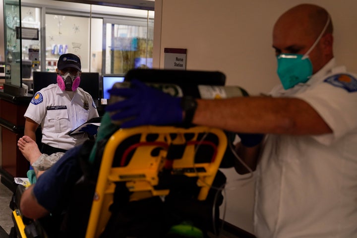 Emergency medical technicians Melanie Cristantos, left, and Ryan Schneider wait for a bed to be cleared in an emergency room at Mission Hospital in Mission Viejo, Calif., Monday, Dec. 21, 2020. (AP Photo/Jae C. Hong)