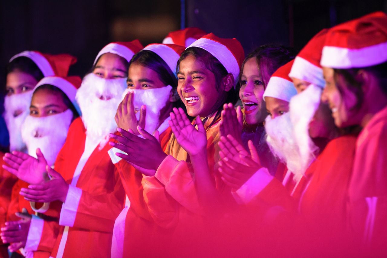 Αγόρια και κορίτσια ντυμένα Άγιος Βασίλης ενώ τραγουδούν κάλαντα στο Κατμαντού του Νεπάλ