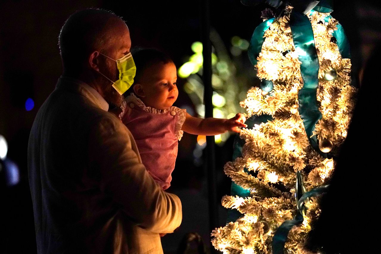 Πατέρας και κόρη μπροστά στο Χριστουγεννιάτικο δέντρο.