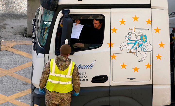 A lorry driver shows their credentials to a member of the British Army as they enter the Port of Dover on Christmas Day.