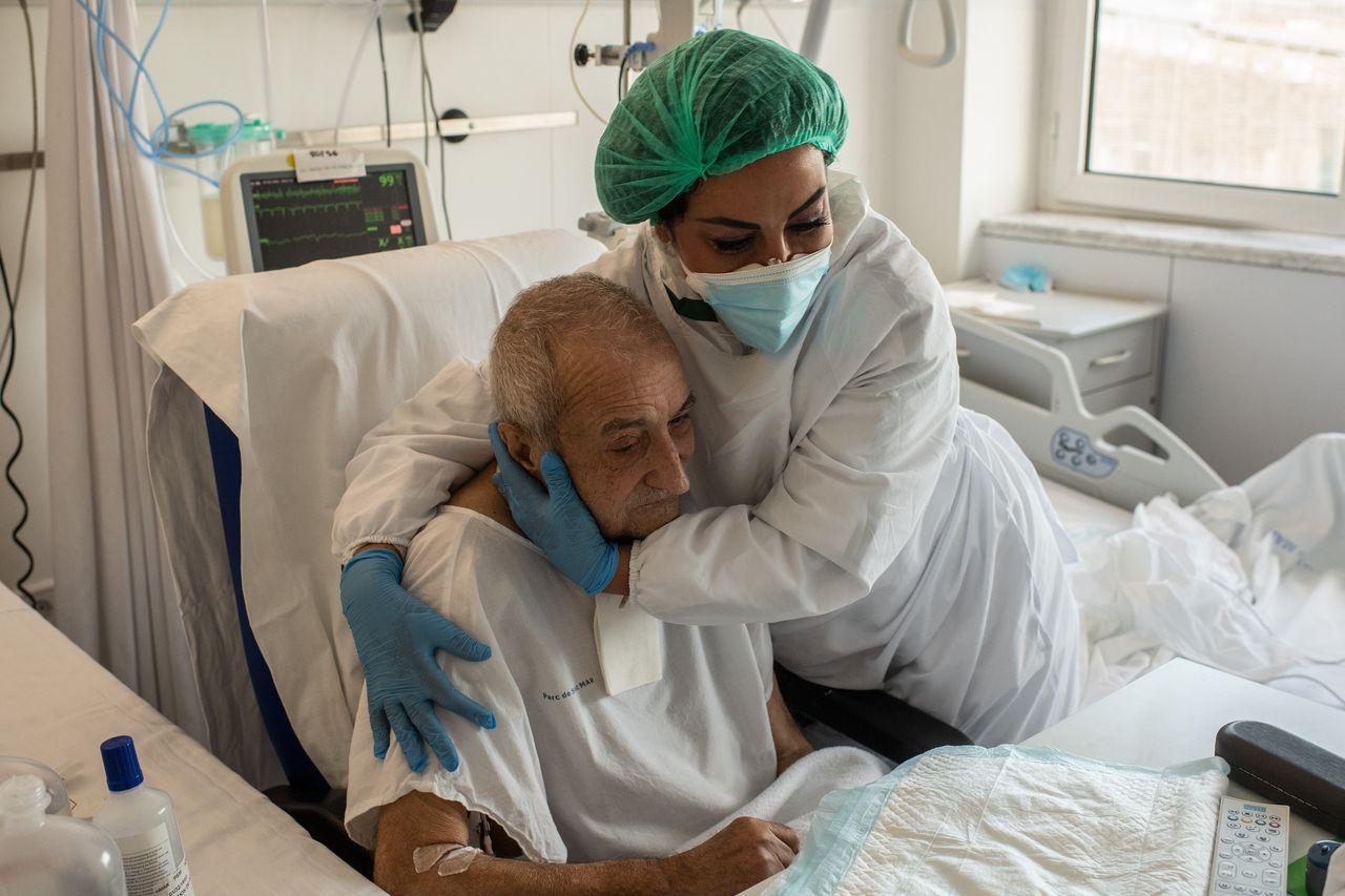 Ισπανία, 25 Δεκεμβρίου 2020. Το νοσηλευτικό προσωπικό είναι αυτό που θα δώσει μια πολυπόθητη αγκαλιά στον Αντόνιο Βιλεκάμπα. Το όνομα της νοσηλεύτριας είναι Λάουρα Καρτιζάνο και είναι αυτή που τον παρηγορεί που δεν μπορεί να είναι με τους αγαπημένους του. (Photo by David Ramos/Getty Images)