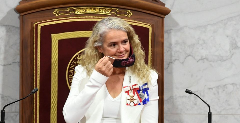 Gov. Gen. Julie Payette removes her face mask before delivering the throne speech in the Senate chamber...