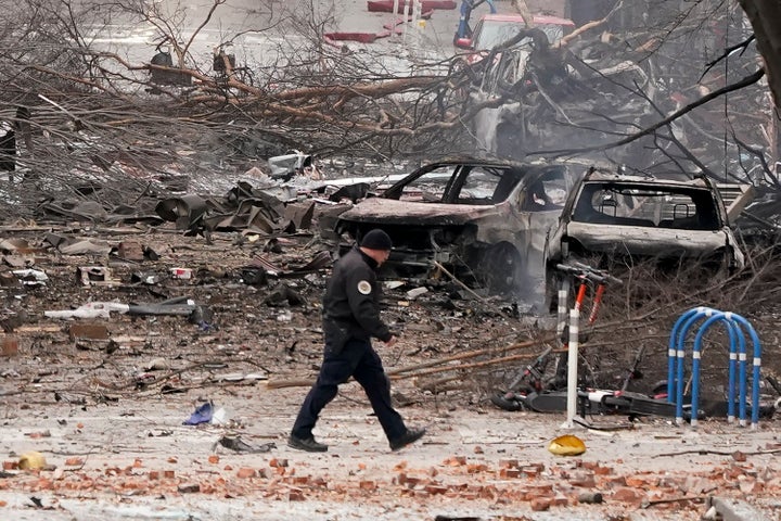 A law enforcement member walks past damage from an explosion in downtown Nashville, Tenn., Friday, Dec. 25, 2020. Buildings shook in the immediate area and beyond after a loud boom was heard early Christmas morning. (AP Photo/Mark Humphrey)