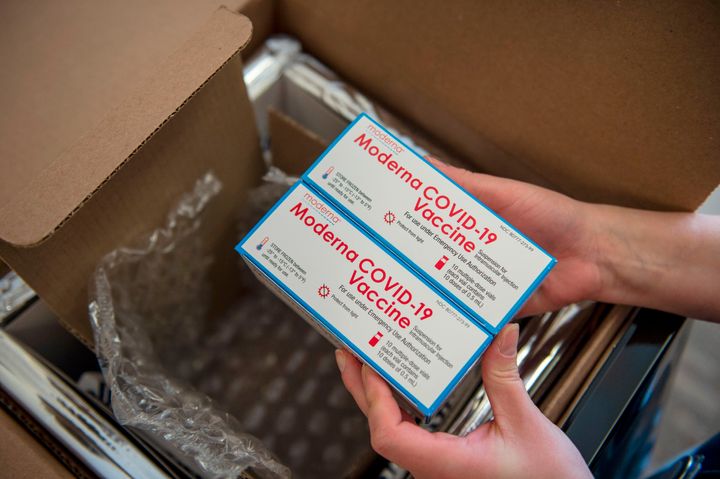 A registered nurse unpacks a special refrigerated box of Moderna COVID-19 vaccines as she prepares to ready more supply for use at the East Boston Neighborhood Health Center in Boston, Massachusetts on Dec. 24, 2020.