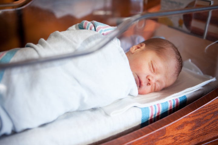 A beautiful 1 day old baby boy sleeping in the hospital nursery.