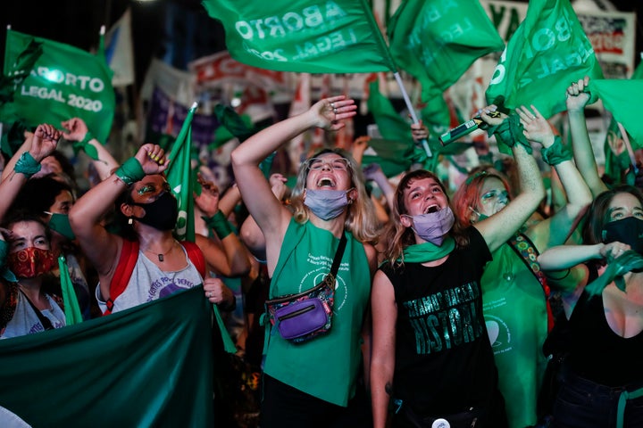Abortion-rights activists watch live video streaming of lawmakers in session, outside Congress in Buenos Aires, Argentina, on