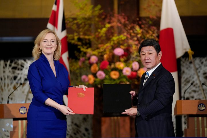 Trade secretary Liz Truss, left, and Japanese foreign minister Toshimitsu Motegi exchange agreement documents for economic partnership between Japan and Britain