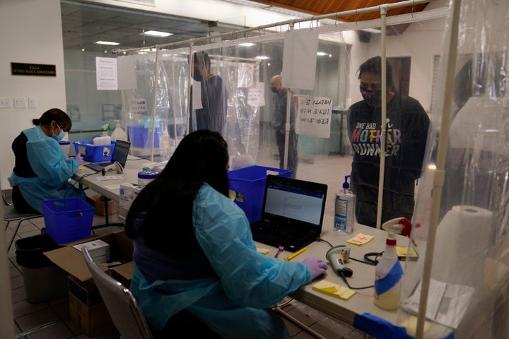 Hospitals in central and Southern California are quickly running out of intensive care unit beds for coronavirus patients. Administrative workers are seen checking people in at a COVID-19 testing site in Los Angeles on Dec. 27. 