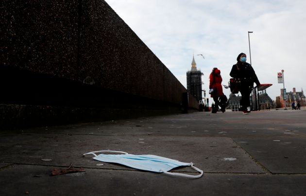 A mask on the pavement near the entrance of a hospital on Westminster Bridge in London, Wednesday, Dec....