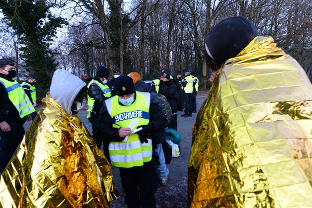 French police writes down the details of youth following the break up of a party near a disused hangar in Lieuron.