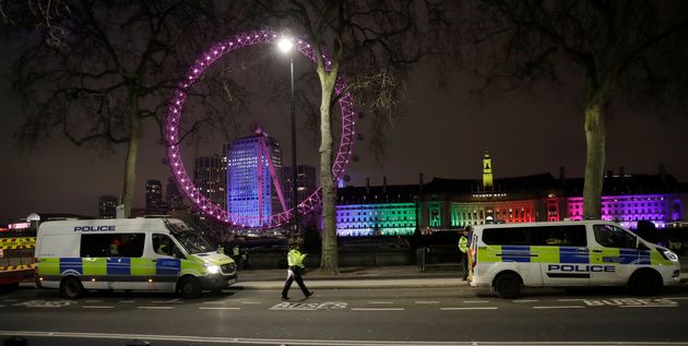 Police officers with two police vans patrol opposite the London Eye 