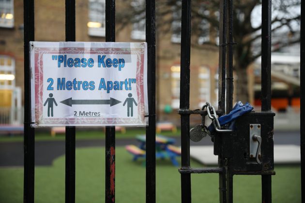  A social distancing sign hangs on a primary school gate in the Borough of Lewisham on January 04, 2021 in London, England. 