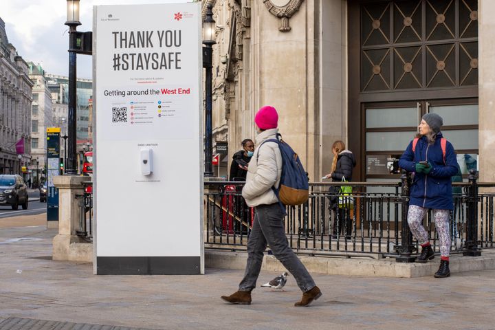 People walk past a Thank You Stay Safe Sign in Oxford Circus. Under tier four restrictions, pubs and restaurants are closed