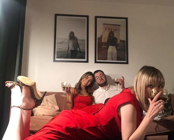 Alexandra Haddow raising a glass with her two housemates