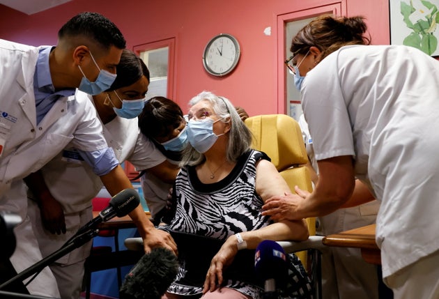 Health workers speak with Mauricette, a 78-year-old French woman, after she received the first dose of the Pfizer-BioNTech coronavirus disease in the country.