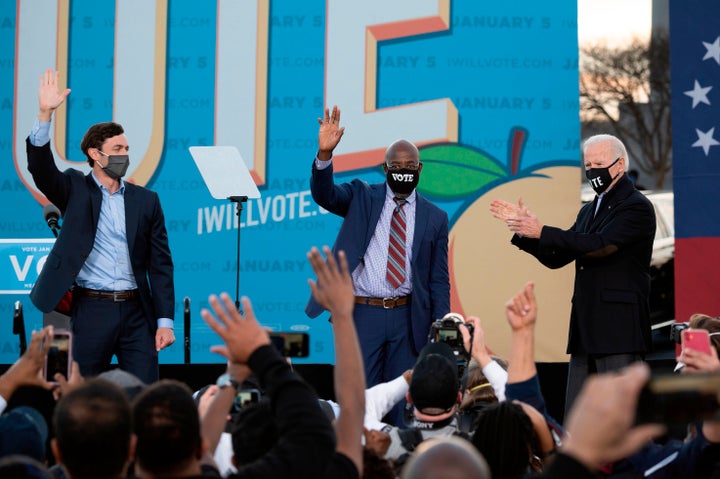 Democratic candidates for Senate Jon Ossoff (L), Raphael Warnock (C) and President-elect Joe Biden (R) stand on stage during a rally outside Center Parc Stadium in Atlanta, Georgia, on January 4, 2021. (Photo by JIM WATSON/AFP via Getty Images)