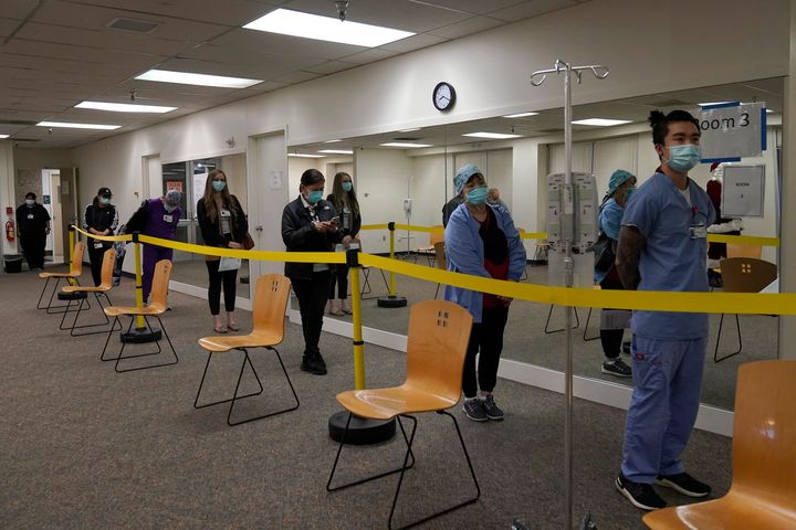 Healthcare workers wait in line to receive the Pfizer-BioNTech COVID-19 vaccine at Seton Medical Center in Daly City, Calif. (AP Photo/Jeff Chiu, File)