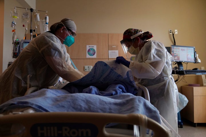 Registered nurses Robin Gooding, left, and Johanna Ortiz treat a COVID-19 patient at Providence Holy Cross Medical Center in the Mission Hills section of Los Angeles. (AP Photo/Jae C. Hong, File)