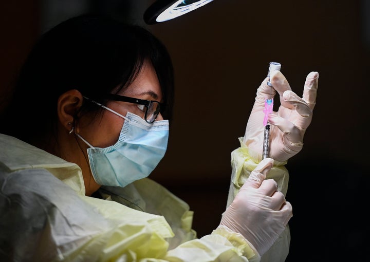 Francesca Paceri, a registered pharmacist technician carefully fills the Pfizer-BioNTech COVID-19 mRNA vaccine at a vaccine clinic in Toronto on Dec. 15, 2020. 