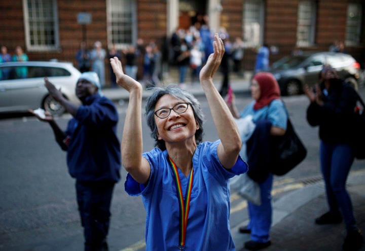 An NHS worker applauds at St Mary's hospital during the Clap for our Carers campaign in support of the NHS.