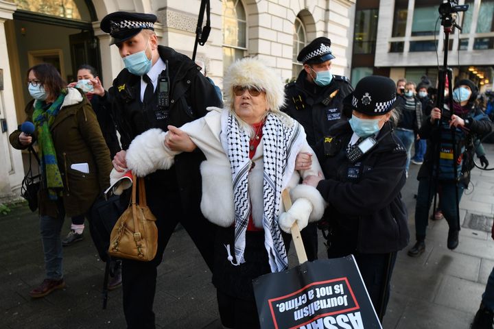 Police arrest a supporter of Wikileaks founder Julian Assange outside Westminster Magistrates court in London on Wednesday
