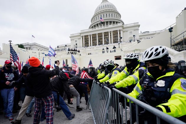Des partisans de Donald Trump tentent de franchir une barrière policière, au Capitole à Washington, le 6 janvier 2021.