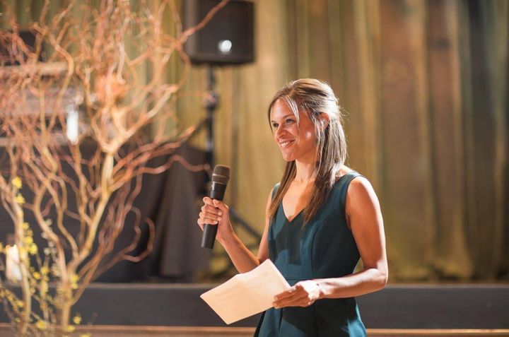 The author giving a toast while rocking her elusive straight hair at her sister's wedding in 2016. ("Needless to say, chemicals were involved," she said.)