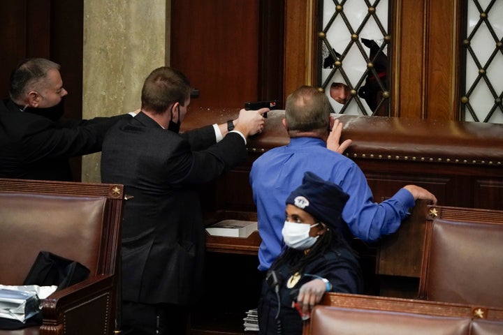 Police with guns drawn watch as protesters try to break into the House Chamber at the U.S. Capitol on Wednesday, Jan. 6, 2021, in Washington. (AP Photo/J. Scott Applewhite)