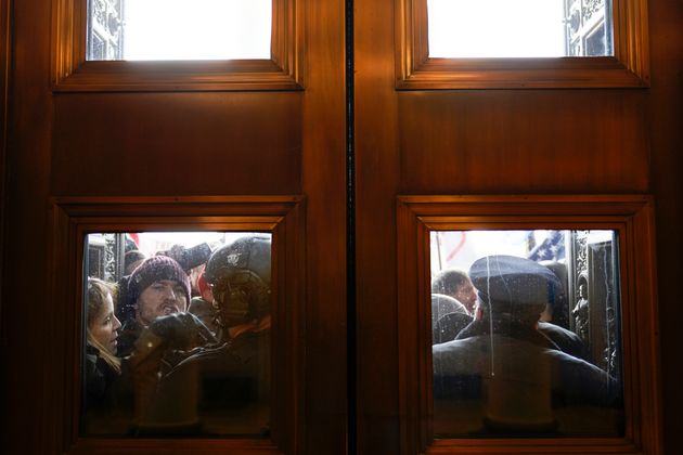 U.S. Capitol Police try to hold back protesters outside the east doors to the House side of the U.S....