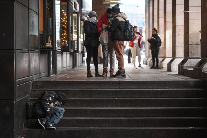 A homeless man sleeps on a set of stairs in London.