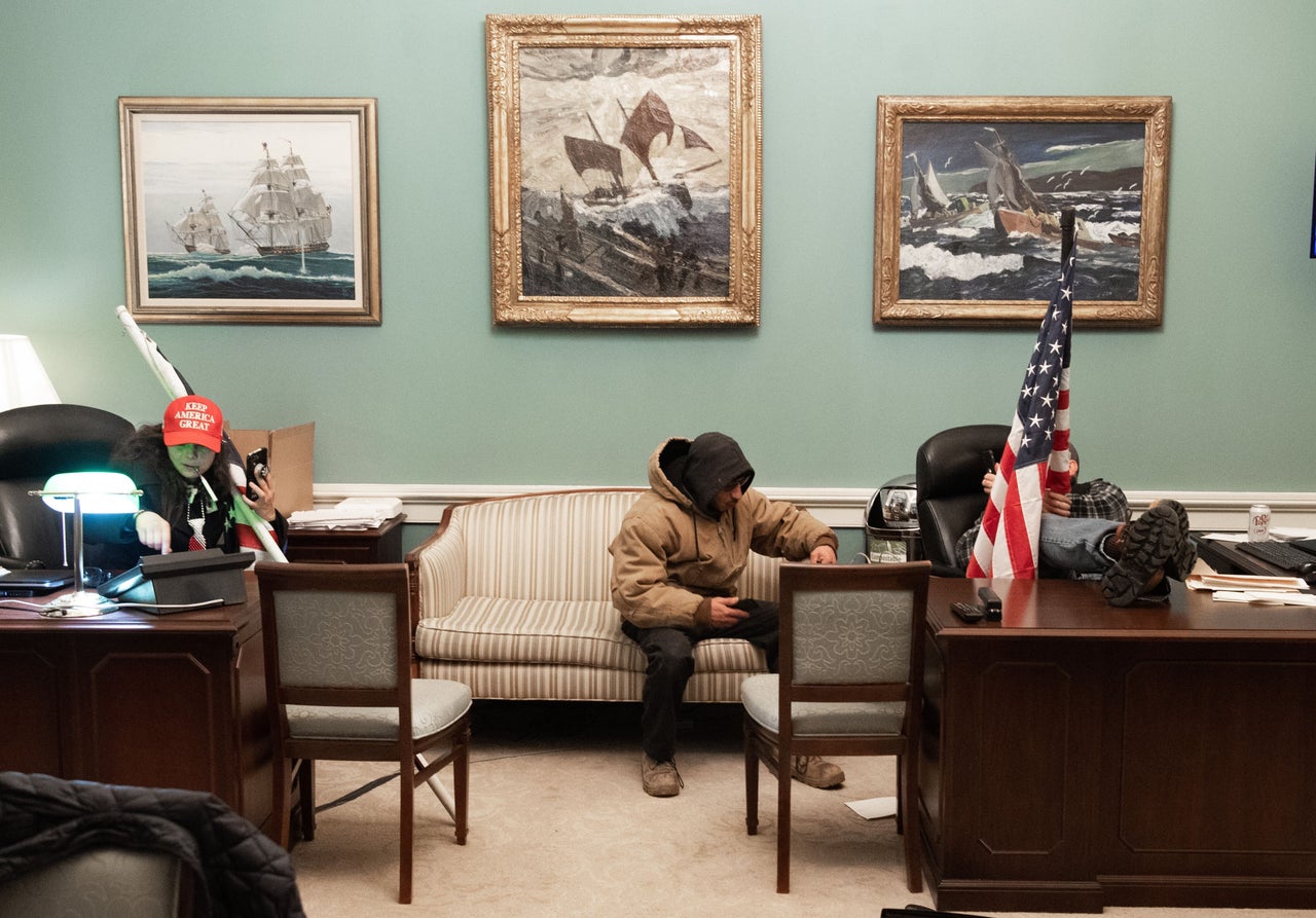 Intruders holding American flags invade Pelosi's office suite in the U.S. Capitol.