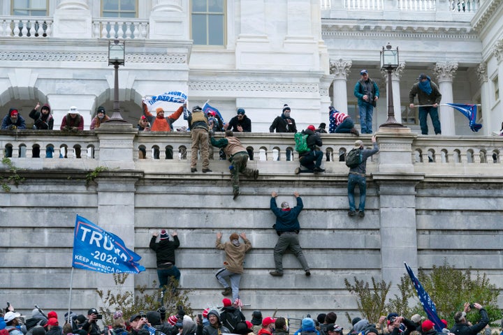 Supporters of President Donald Trump climb the west wall of the the U.S. Capitol on Wednesday, Jan. 6, 2021, in Washington. (AP Photo/Jose Luis Magana)