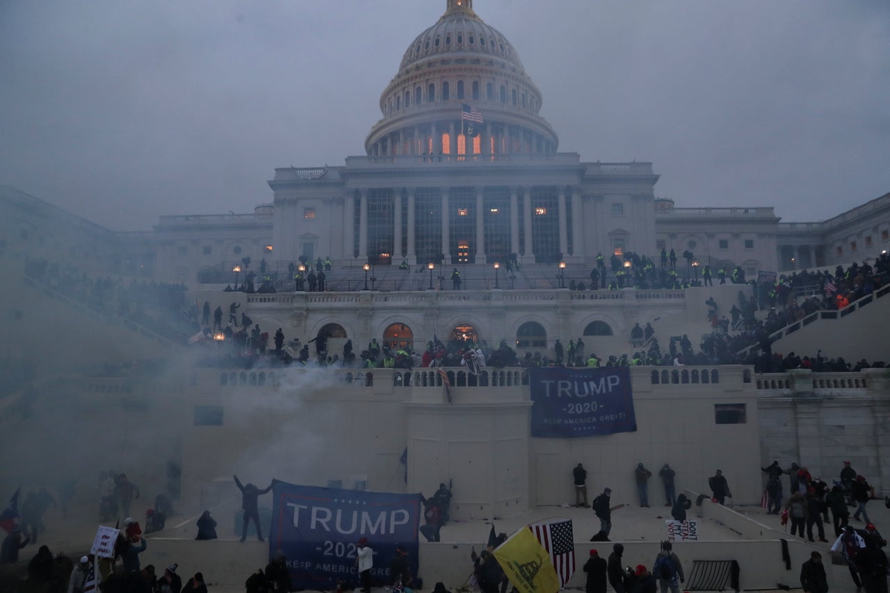 Police officers stand guard as Trump supporters gather in front of the Capitol after rioters stormed the building.