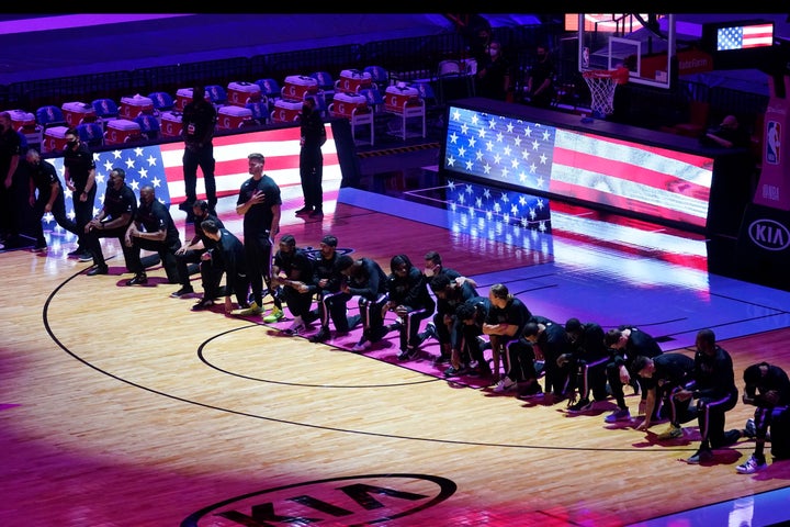 The Boston Celtics team kneels during the playing of the National Anthem before the first half of an NBA basketball game against the Miami Heat, Wednesday, Jan. 6, 2021, in Miami.