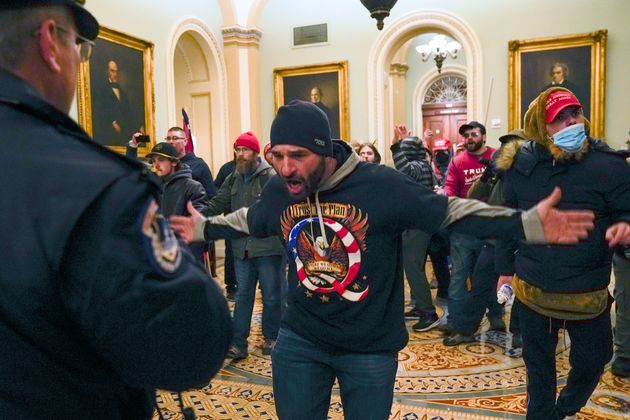 Trump supporters gesture to U.S. Capitol Police in the hallway outside of the Senate chamber at the Capitol in Washington