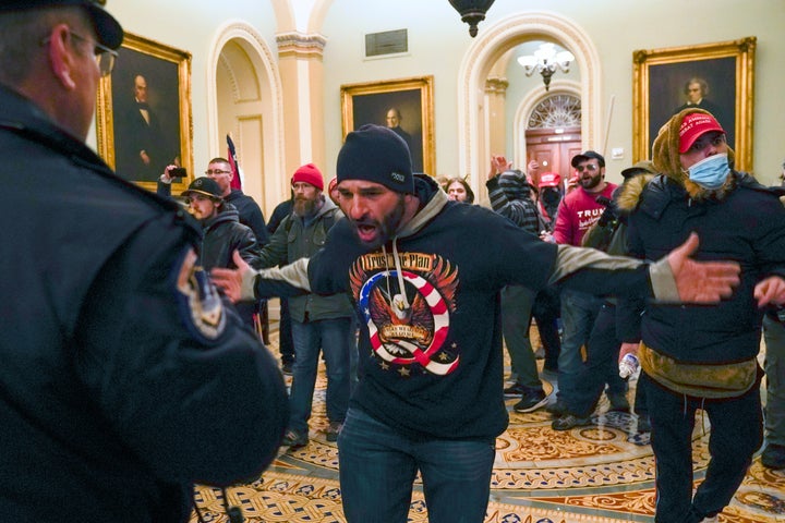 Trump supporters gesture to U.S. Capitol Police in the hallway outside of the Senate chamber at the Capitol in Washington