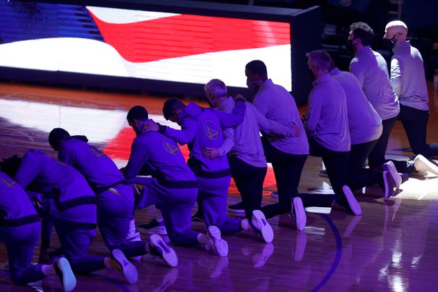 Les joueurs des Golden State Warriors, genou à terre lors de l'hymne américain avant le match face aux LA Clippers, le 6 janvier 2021 à San Francisco en Californie.