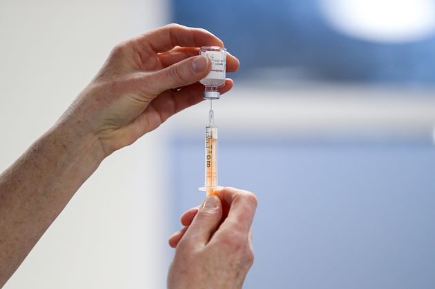 A healthcare worker fills a syringe with a dose of Oxford/AstraZeneca coronavirus vaccine at the Pentland Medical Practice, in Currie, Scotland