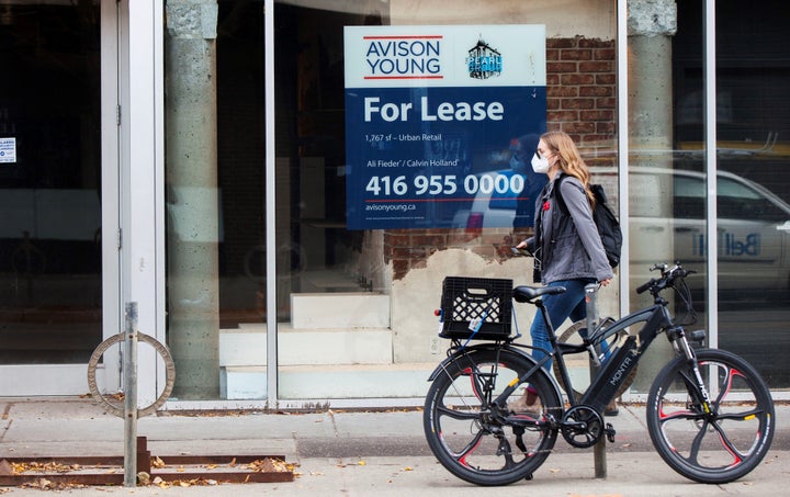 A woman wearing a face mask walks on a street in Toronto, Nov. 6, 2020. Canada's job recovery stalled in December, Statistics Canada data shows.