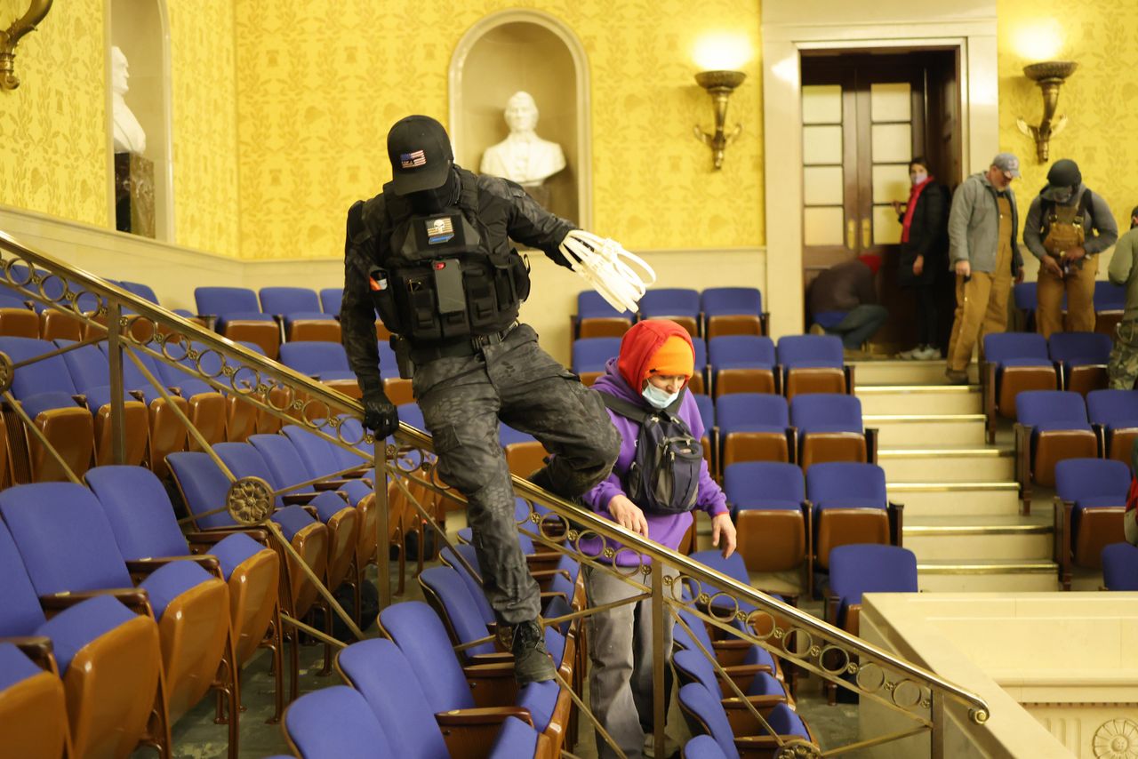 A rioter dressed in tactical gear carries zip-tie handcuffs in the Senate Chamber on Wednesday.