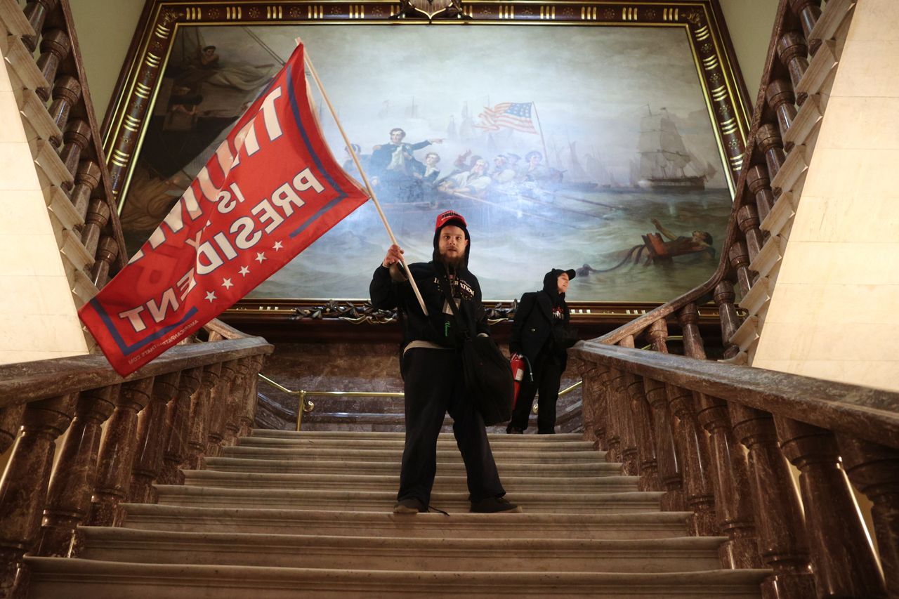 A rioter holds a Trump flag inside the Capitol near the Senate Chamber on Wednesday.