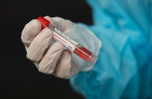 A nurse holds a vial containing a patients test swab on November 18, 2020 in