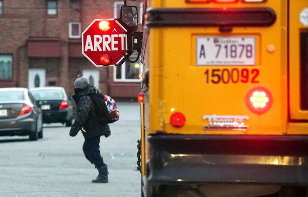 Young boy getting off a school bus in Montreal, Que., Thursday, December 3,
