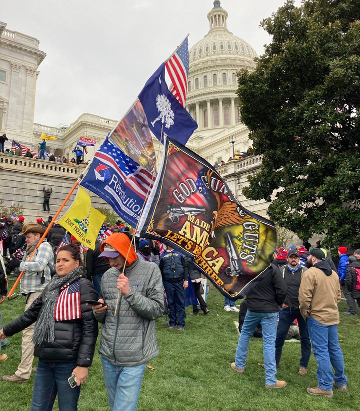 People hold flags glorifying violence and religion near the U.S. Capitol, which was breached on Jan. 6 by thousands of rioters who rejected the results of the 2020 presidential election.