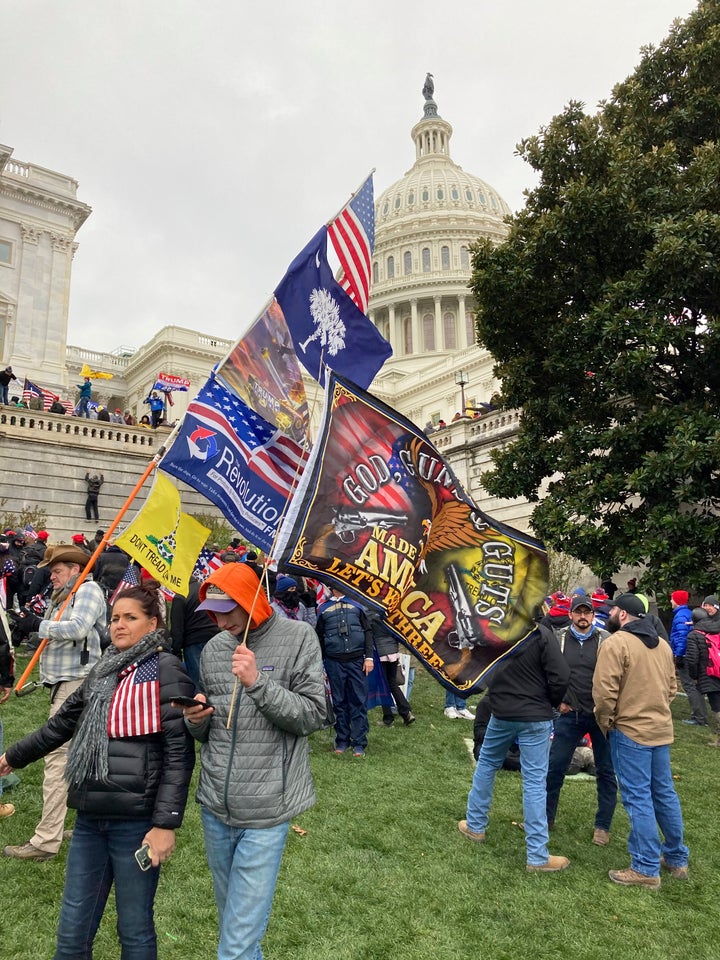 People hold flags near the U.S. Capitol, which was breached on Jan. 6 by thousands of rioters who disagreed with the results of the 2020 presidential election.