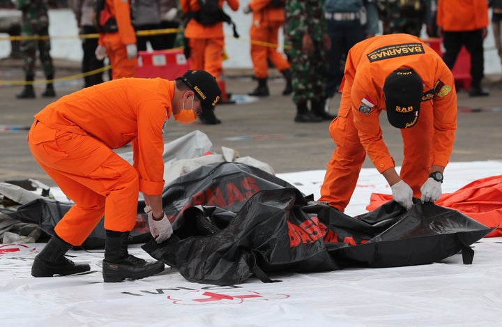 Rescuers carry a body bag containing human remains recovered from the waters where Sriwijaya Air passenger jet crashed.