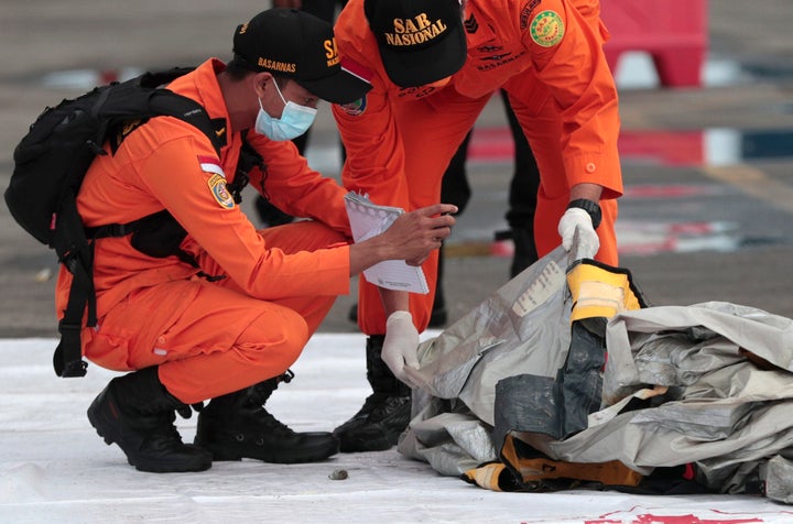 Rescuers inspect debris found in the waters around the location where a Sriwijaya Air passenger jet has lost contact with air